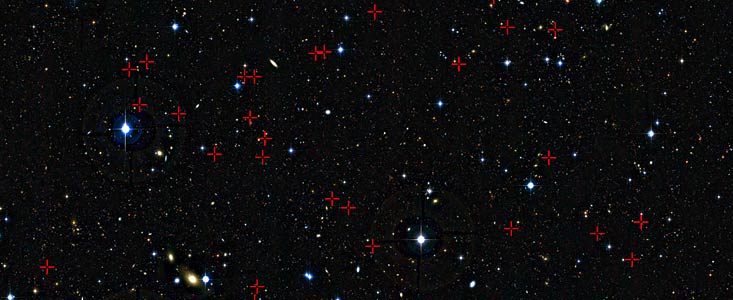 Esta imagen profunda de una pequeña parte del cielo en la constelación de Cetus (el monstruo marino o la ballena) muestra una selección de galaxias marcadas con cruces rojas, utilizadas en un nuevo sondeo para estudiar los hábitos alimentarios de galaxias jóvenes a medida que crecen con el paso del tiempo. Cada una de las pequeñas burbujas, galaxias vistas tal y como eran entre tres mil y cinco mil millones de años tras el Big Bang, ha sido estudiada con detalle utilizando el telescopio VLT de ESO y el instrumento SINFONI.